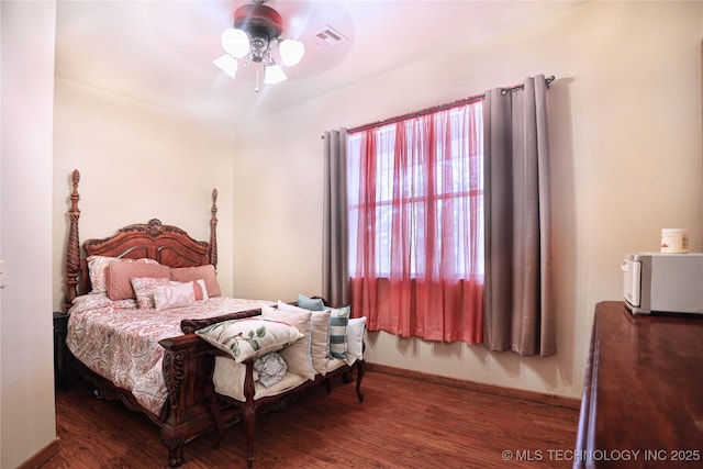 bedroom featuring ceiling fan, baseboards, and dark wood-type flooring