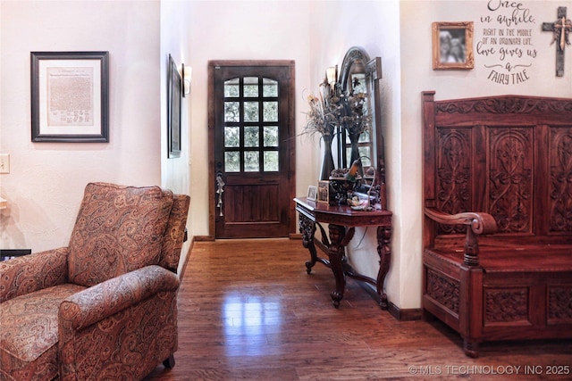 foyer with dark wood-type flooring and baseboards