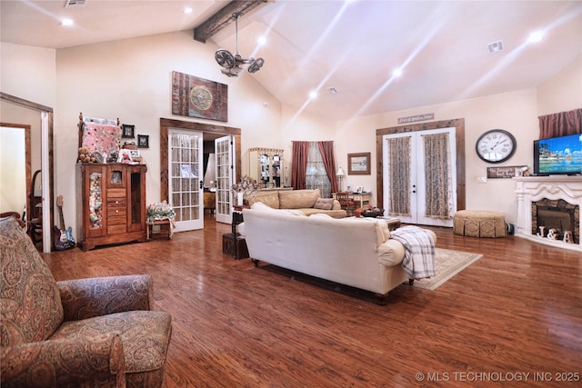 living area with a fireplace, visible vents, wood finished floors, and french doors