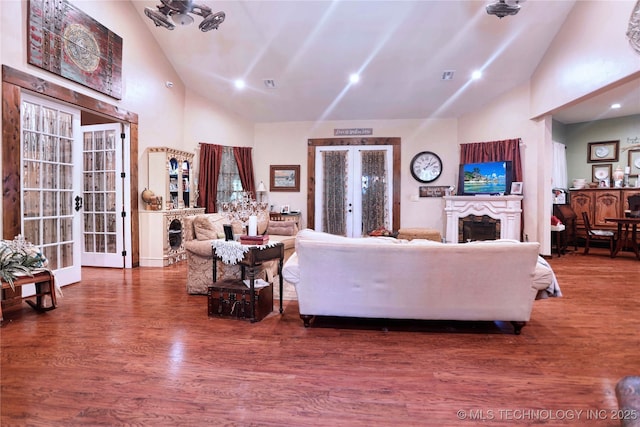 living room with french doors, visible vents, a fireplace, and wood finished floors