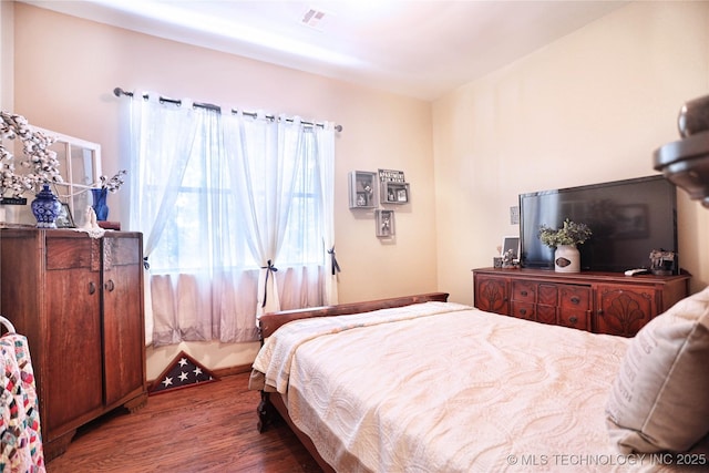 bedroom with visible vents and dark wood finished floors