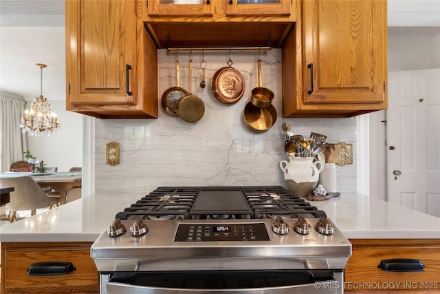 kitchen with stainless steel gas range, tasteful backsplash, and brown cabinetry