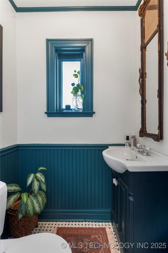 bathroom with wainscoting, vanity, and toilet