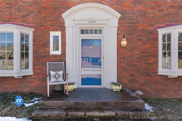 view of exterior entry featuring brick siding