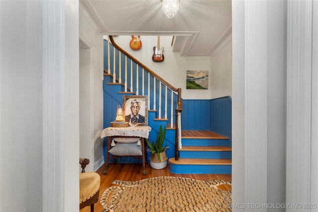 stairway featuring crown molding and wood finished floors