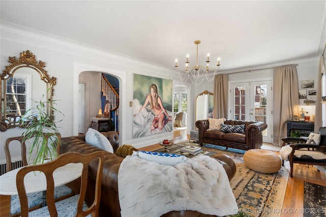 living area featuring arched walkways, ornamental molding, and wood finished floors