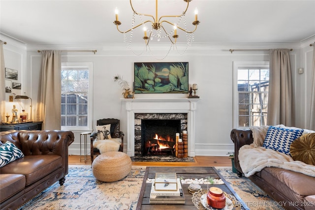 living room with a premium fireplace, plenty of natural light, wood finished floors, and crown molding