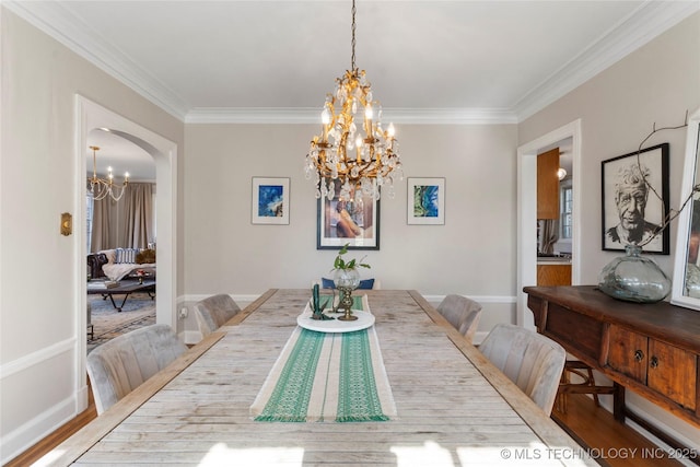 dining room featuring a chandelier, wood finished floors, arched walkways, and ornamental molding