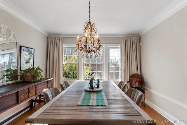 dining area with a notable chandelier, baseboards, ornamental molding, and wood finished floors