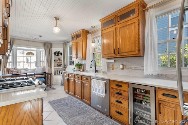 kitchen featuring light tile patterned floors, beverage cooler, brown cabinets, light countertops, and pendant lighting