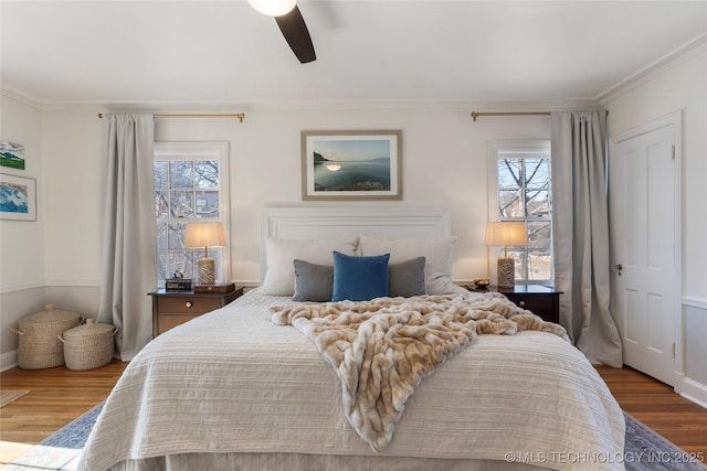 bedroom featuring multiple windows, wood finished floors, and crown molding