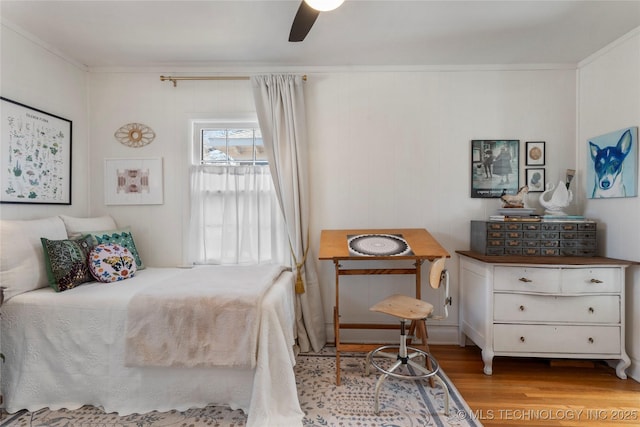 bedroom featuring light wood-style floors, ceiling fan, and ornamental molding