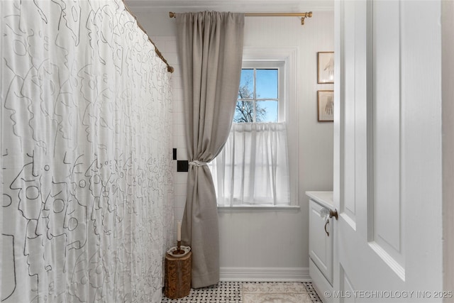 bathroom featuring a shower with shower curtain and baseboards