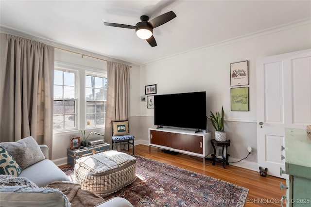 living area featuring ceiling fan, ornamental molding, and wood finished floors