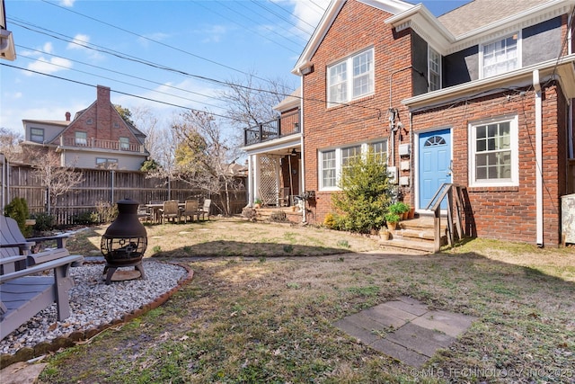 view of yard with fence and a fire pit