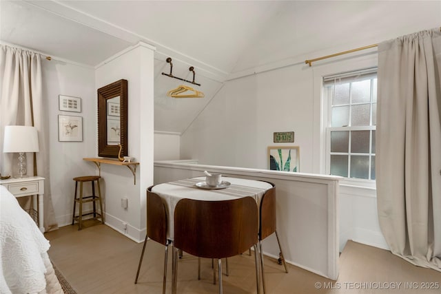 dining space featuring lofted ceiling, light wood-style flooring, and baseboards