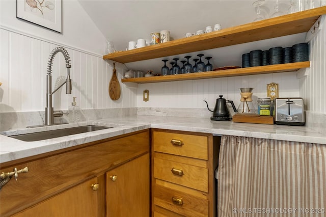 bar featuring vaulted ceiling and a sink