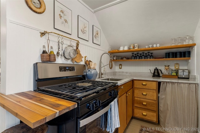 kitchen featuring range with gas stovetop, open shelves, lofted ceiling, a sink, and wood counters