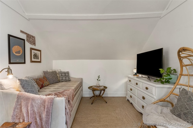 living area featuring vaulted ceiling and baseboards