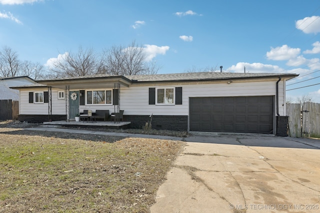 ranch-style house featuring concrete driveway, fence, and an attached garage