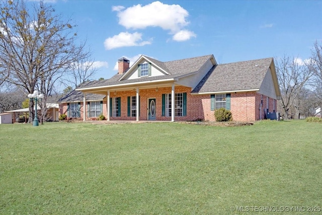 view of front of house featuring a front yard, a chimney, a porch, and brick siding