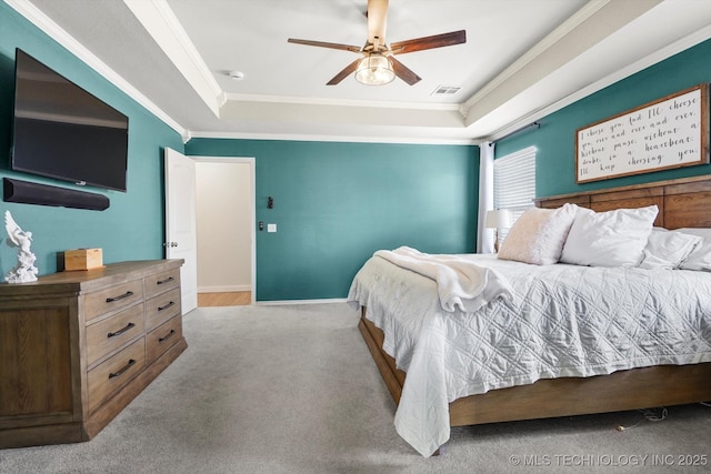 bedroom with carpet floors, a raised ceiling, visible vents, and crown molding