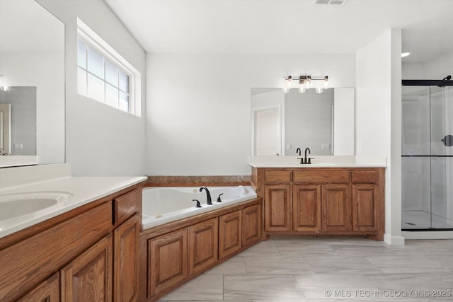 bathroom with a garden tub, two vanities, a sink, and a shower stall