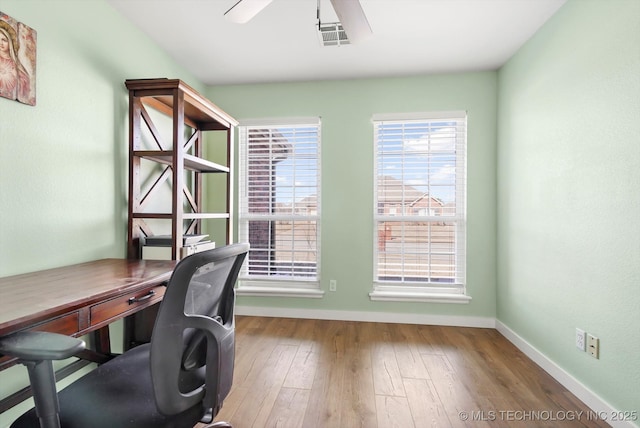 office space featuring hardwood / wood-style flooring, ceiling fan, visible vents, and baseboards