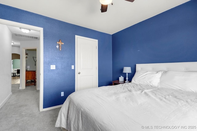 bedroom with arched walkways, carpet flooring, a ceiling fan, visible vents, and baseboards