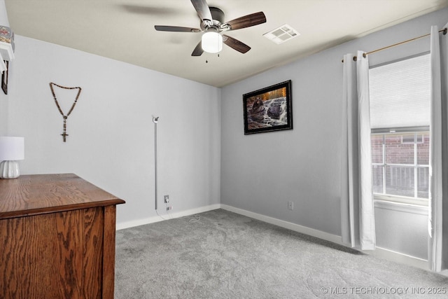 spare room with a ceiling fan, baseboards, visible vents, and carpet flooring