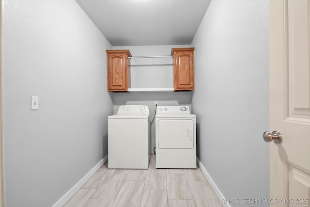 laundry room with washing machine and clothes dryer, cabinet space, and baseboards