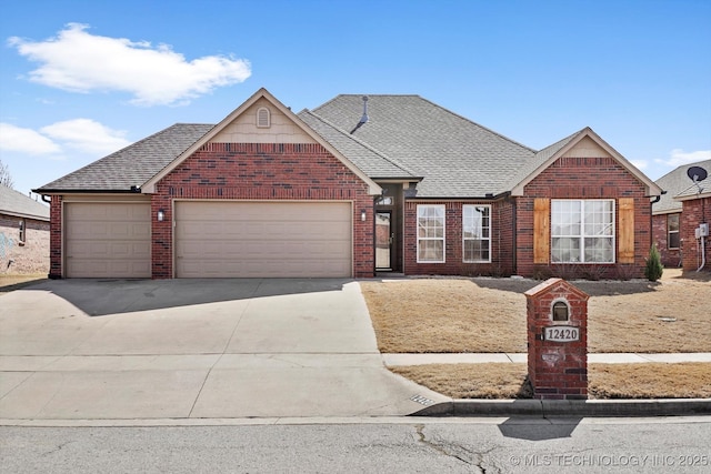 view of front of property with driveway, brick siding, roof with shingles, and an attached garage