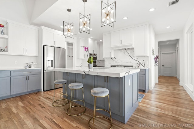 kitchen with decorative light fixtures, open shelves, gray cabinetry, white cabinets, and stainless steel fridge with ice dispenser