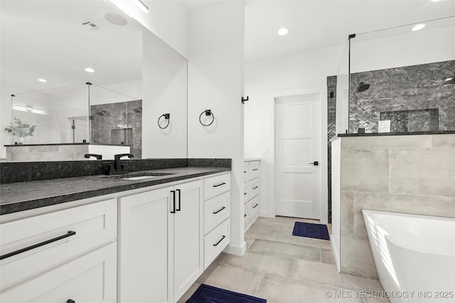 full bathroom with recessed lighting, a freestanding tub, tiled shower, and vanity