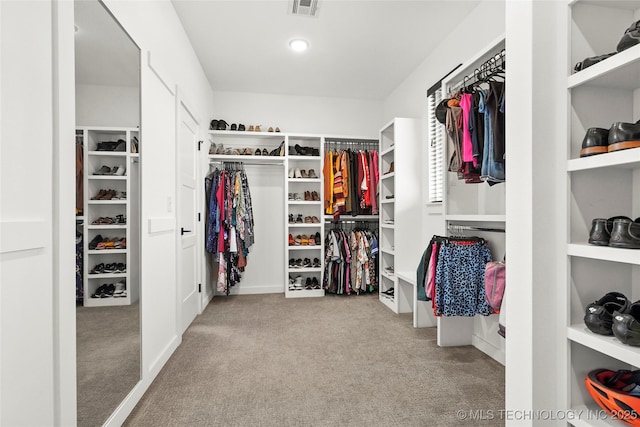 walk in closet featuring light carpet and visible vents