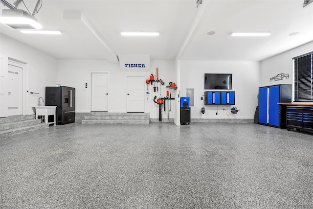 garage with black refrigerator with ice dispenser and a garage door opener