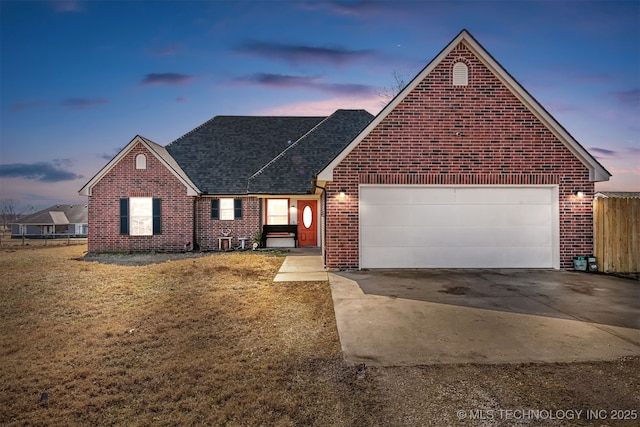 ranch-style house with concrete driveway, roof with shingles, an attached garage, fence, and brick siding