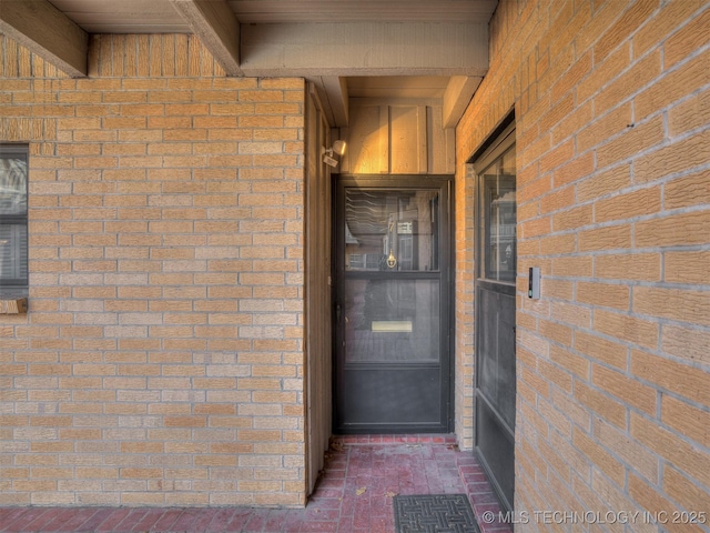 property entrance featuring brick siding