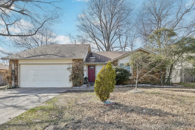 single story home with driveway, stone siding, and an attached garage