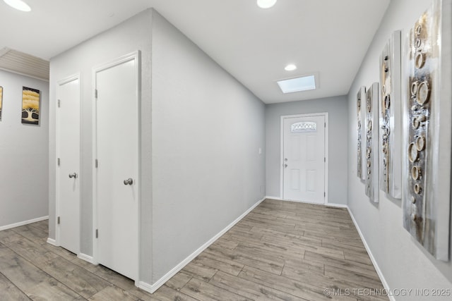 foyer featuring light wood-style floors, baseboards, and recessed lighting