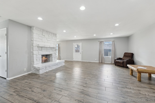 unfurnished living room featuring a fireplace, wood finished floors, and recessed lighting