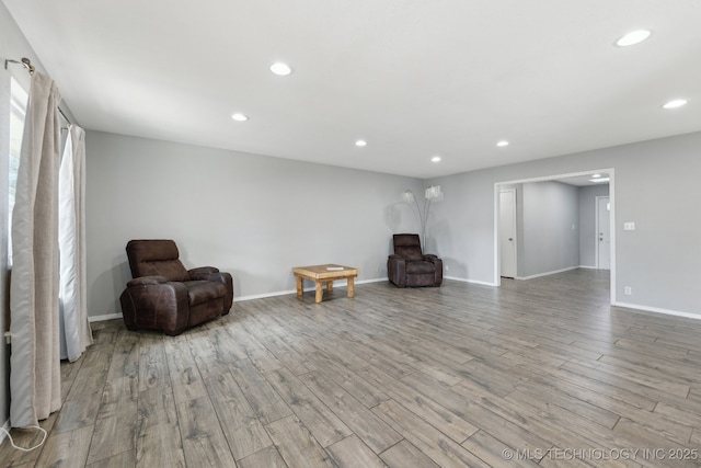 living area with recessed lighting, baseboards, and wood finished floors