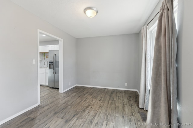 empty room with baseboards and wood finished floors