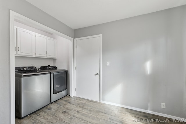 laundry room with light wood-type flooring, cabinet space, baseboards, and washer and dryer