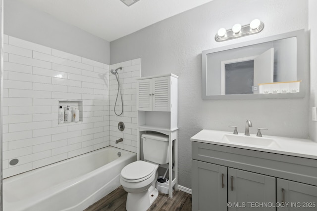 bathroom featuring a textured wall, toilet, washtub / shower combination, vanity, and wood finished floors