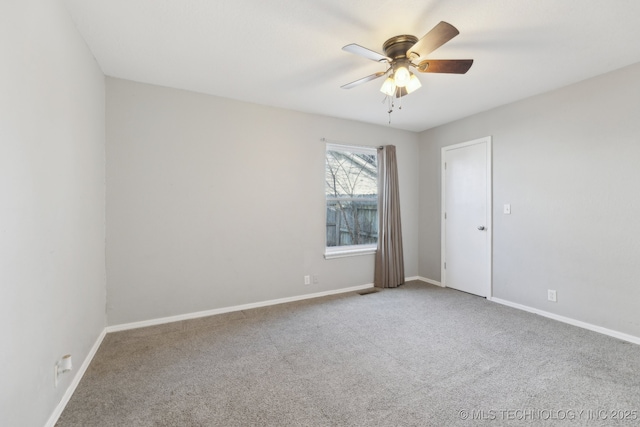 carpeted empty room with baseboards and a ceiling fan