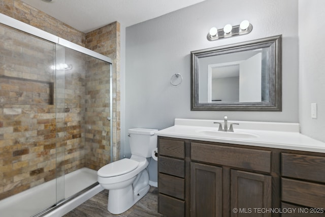 full bath with vanity, a shower stall, and toilet