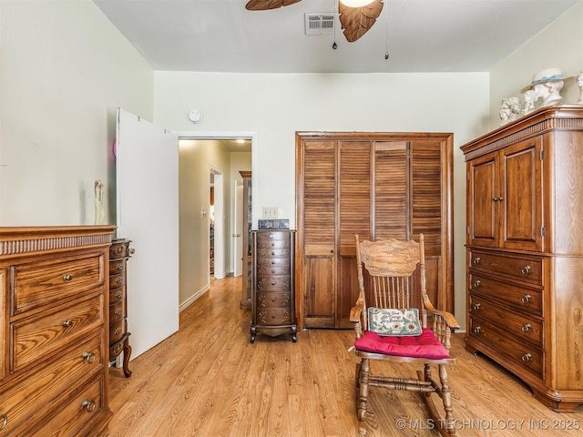 living area featuring a ceiling fan, visible vents, and light wood-style flooring