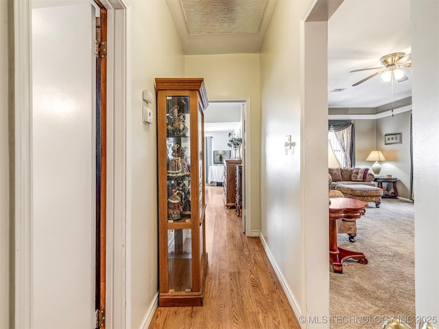 corridor featuring baseboards and wood finished floors