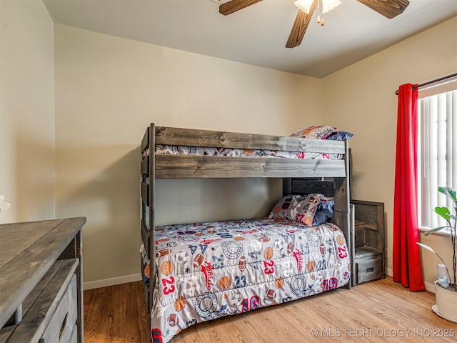 bedroom with a ceiling fan, baseboards, and wood finished floors